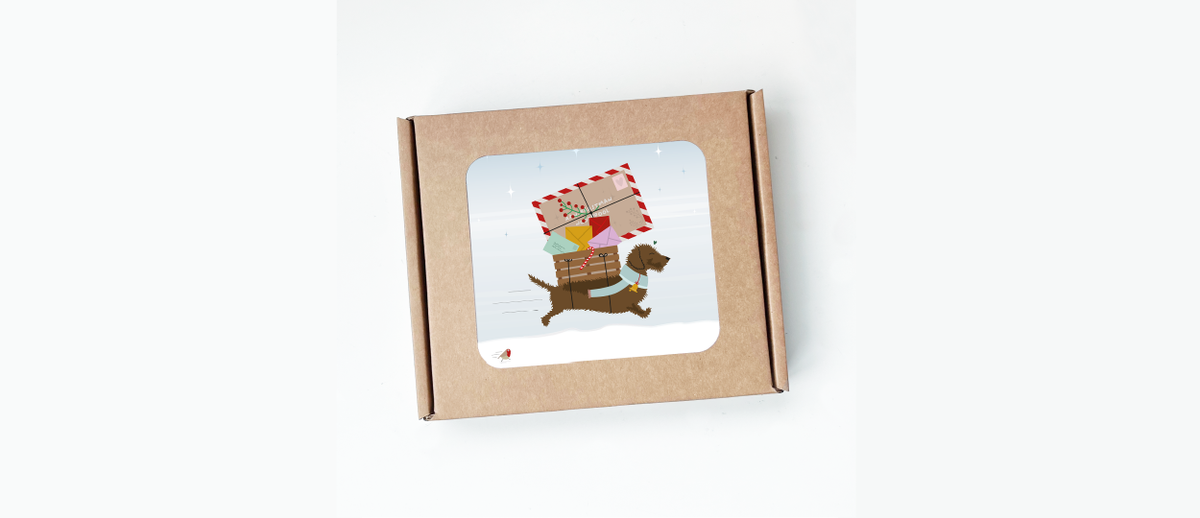 Doosje kerstkaarten met teckel Frits die met een stapel kerstpost door de sneeuw loopt