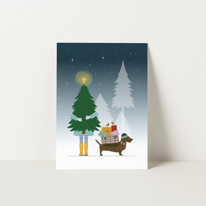 Kerstkaart teckel - Frits sjouwt cadeaus en post naast een kerstboom in de sneeuw