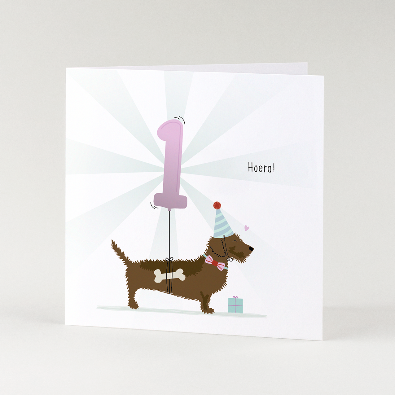 Eerste verjaardag kaart met teckel – feestelijke geïllustreerde teckel wenskaart voor 1 jaar.